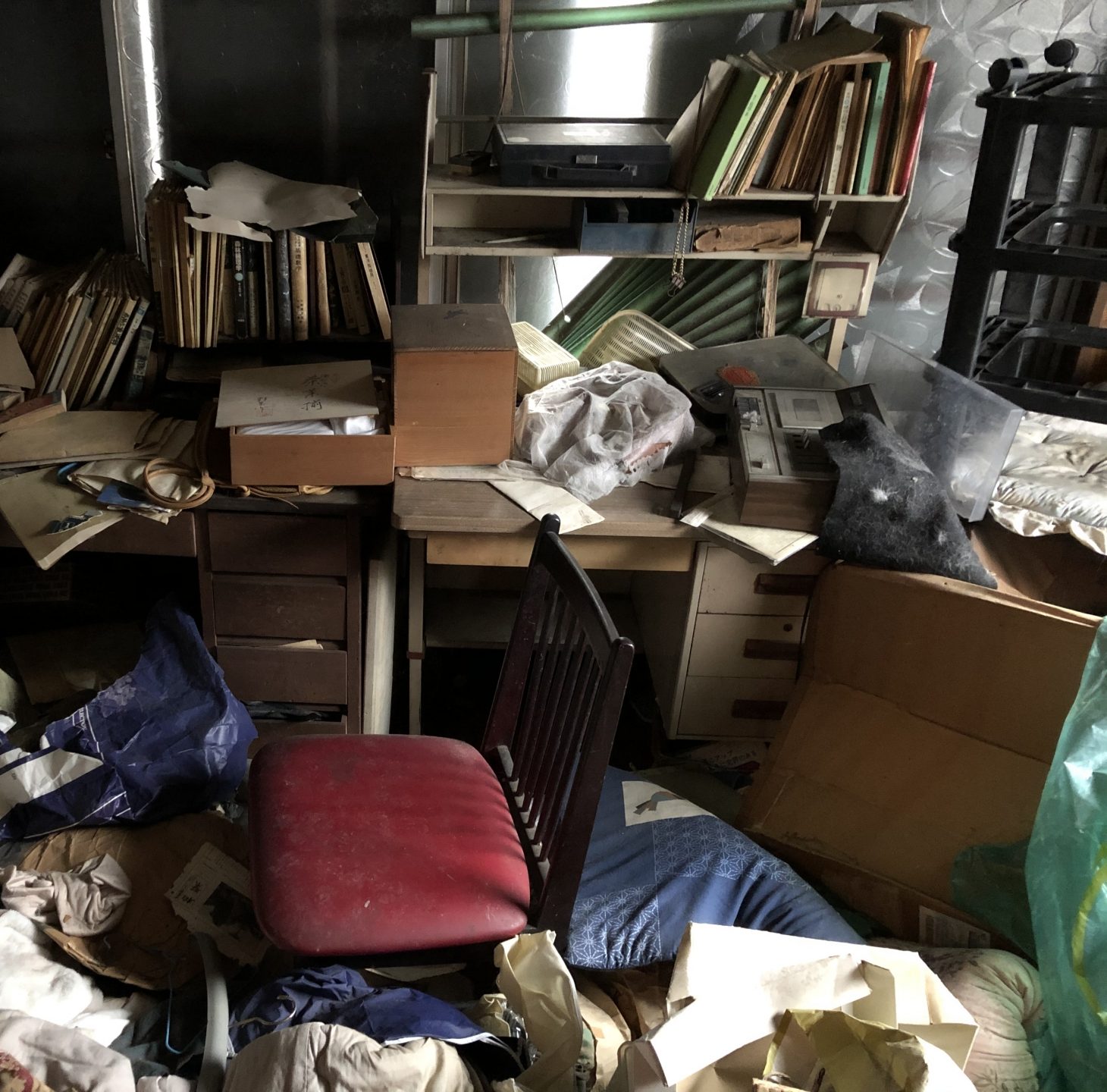 物が床一面に積み重なったゴミ屋敷状態の部屋（三重県の便利屋によるゴミ屋敷片付けのイメージ）