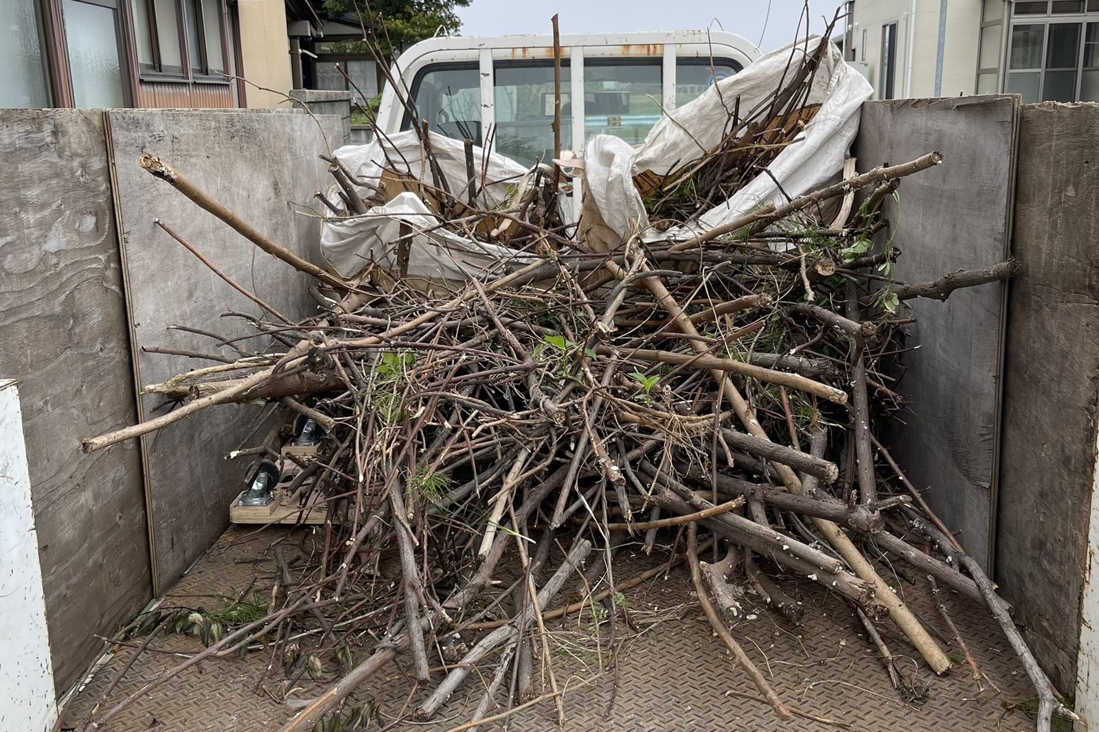 伐採した庭木の枝を軽トラックの荷台に積み込んだ様子